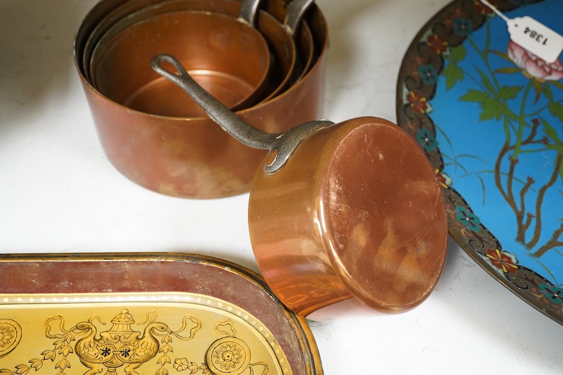 A graduated set of five copper saucepans